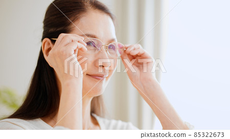 Senior woman wearing reading glasses Senior woman wearing reading glasses 85322673