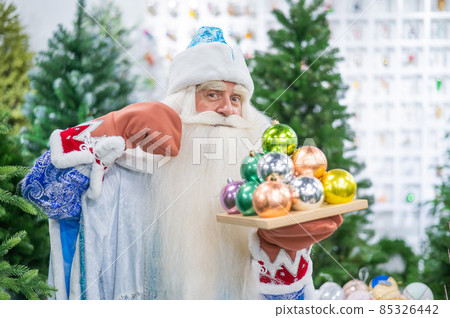 Russian santa claus holds decorations for the christmas tree in the store. Russian santa claus holds decorations for the christmas tree in the store. 85326442