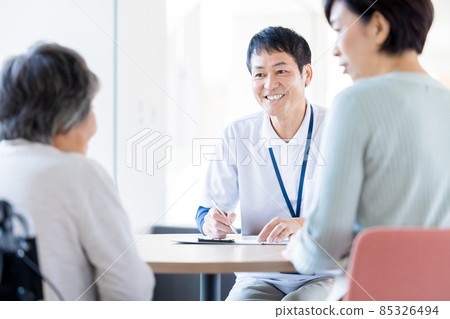 Facility staff explaining to parents and children of long-term care Photo cooperation "LINK FOREST] 85326494