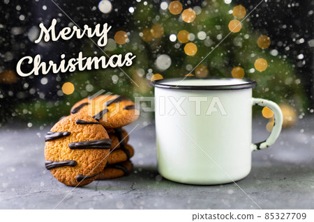 orange cookies with black stripes and cup of tea with fir tree branch. Christmas dessert. Concept for children new year orange cookies with black stripes and cup of tea with fir tree branch. Christmas dessert. Concept for children new year 85327709