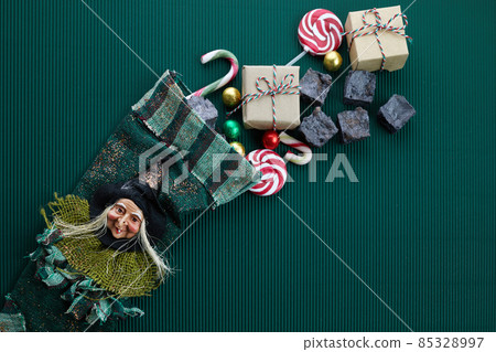 Befana sock with sweet coal and candy on dark greeen background. Italian Epiphany day tradition. Befana sock with sweet coal and candy on dark greeen background. Italian Epiphany day tradition. 85328997