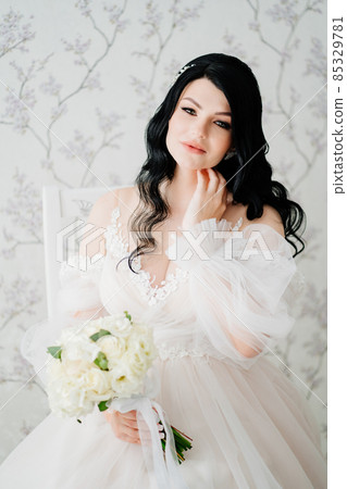 beautiful brunette bride in white dress with bouquet. hair and makeup for bride. 85329781