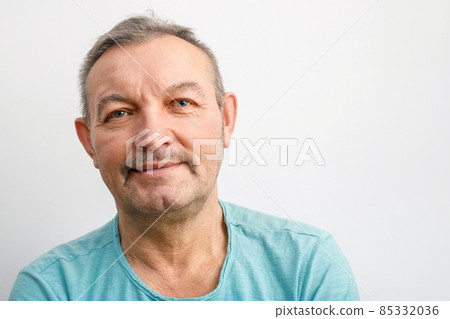 Portrait of a friendly elderly man with a mustache. A gray-haired man smiles looking at the camera 85332036