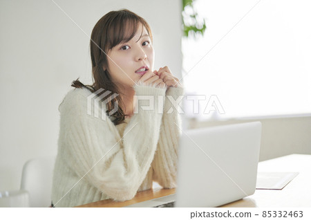 A young woman looking at the camera doing telework 85332463