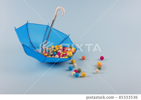 Upturned umbrella with caramel candy. Concept for Dia de Reyes Magos day (Three Wise Men) or Epiphany day.  85333536