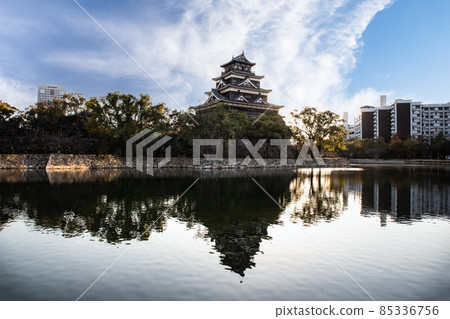 是廣島城的天守閣和中央公園的風景。護城河表面有陰影。 是廣島城的天守閣和中央公園的風景。護城河表面有陰影。 85336756