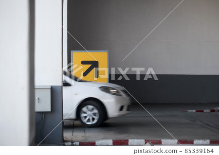 Way up - into the building's parking lot with a sign up right arrow. Arrow sign in yellow and black high above from ground to direct the car in the right direction. Direction up and down for safety. Way up - into the building's parking lot with a sign up right arrow. Arrow sign in yellow and black high above from ground to direct the car in the right direction. Direction up and down for safety. 85339164