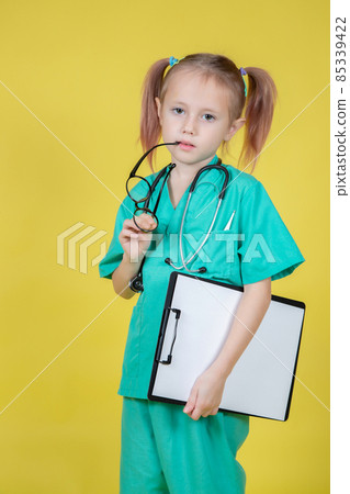 Portrait of serious little kid dressed in doctors coat with a tablet in hand 85339422