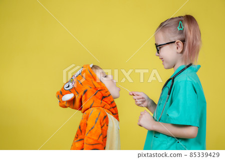 boy in tiger costume shows throat to pediatrician at doctor's appointment boy in tiger costume shows throat to pediatrician at doctor's appointment 85339429