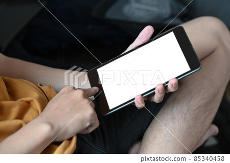 Young man sitting on couch and using digital tablet. Young man sitting on couch and using digital tablet. 85340458