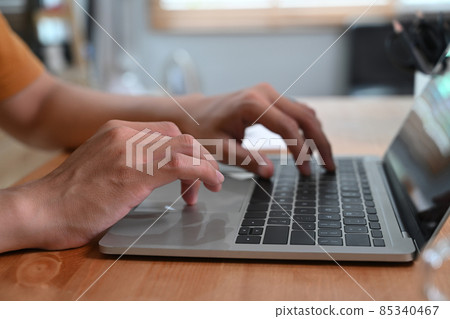 Close up view man typing on keyboard of laptop computer. Close up view man typing on keyboard of laptop computer. 85340467