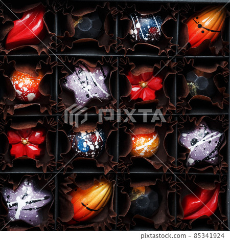 Colorful handmade chocolates in a box on a dark background 85341924
