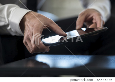 Man in white shirt using a tablet Man in white shirt using a tablet 85343876