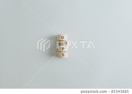 Oops sign spelled on stacked wooden cut circles 85343885