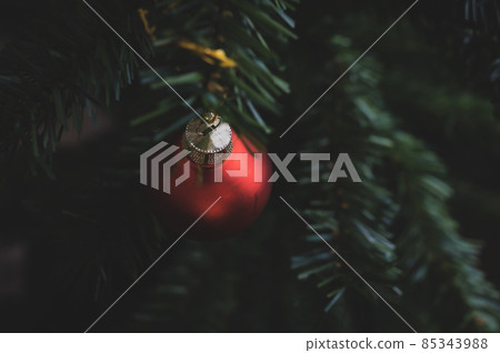 Top view of red bauble hanging from a Christmas tree Top view of red bauble hanging from a Christmas tree 85343988