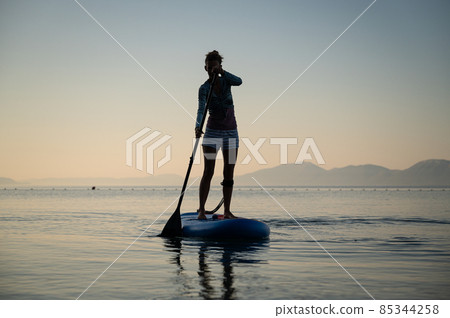 Young woman paddling on a sup board Young woman paddling on a sup board 85344258