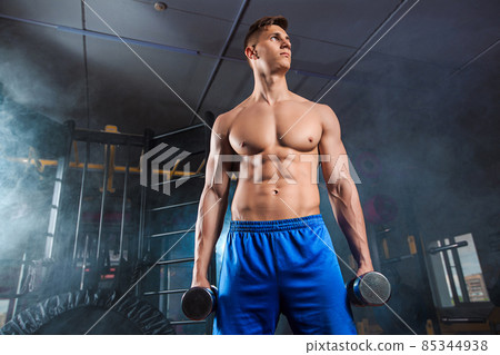 Man doing heavy weight exercise with dumbbells in gym 85344938