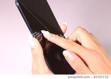 Female hands operating a smartphone Female hands operating a smartphone 85345118