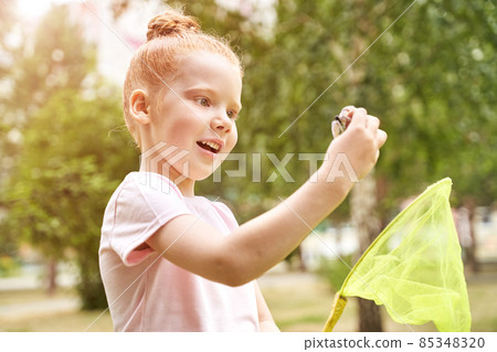 Little girl playing with butterfly net. Summer adventure. Happy toddler Little girl playing with butterfly net. Summer adventure. Happy toddler 85348320