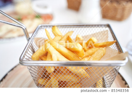 Basket with french fry. Potato chips. Cooking uhealthy lunch. Basket with french fry. Potato chips. Cooking uhealthy lunch. 85348356