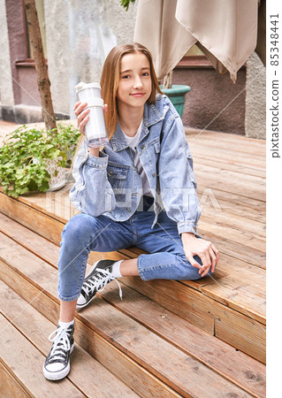Pretty girl drink beverage outdoors. Buy takeaway coffee in own cup. Real people Pretty girl drink beverage outdoors. Buy takeaway coffee in own cup. Real people 85348441
