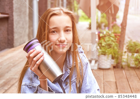 Pretty girl drink beverage outdoors. Buy takeaway coffee in own cup. Real people Pretty girl drink beverage outdoors. Buy takeaway coffee in own cup. Real people 85348448