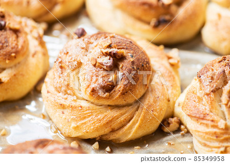 Freshly baked nuts and cardamom sweet buns. Yeasted pastry and cozy baking. Freshly baked nuts and cardamom sweet buns. Yeasted pastry and cozy baking. 85349958