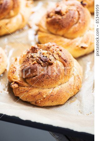 Freshly baked nuts and cardamom sweet buns. Yeasted pastry and cozy baking. Freshly baked nuts and cardamom sweet buns. Yeasted pastry and cozy baking. 85349959