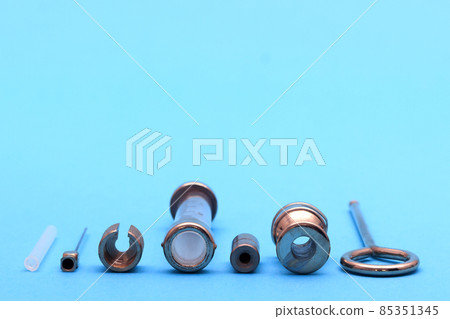antique syringe disassembled into details on a blue background antique syringe disassembled into details on a blue background 85351345
