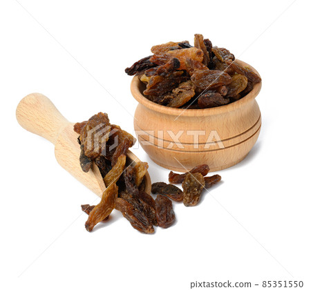 dried brown raisins in wooden bowl and spoon isolated on white background 85351550