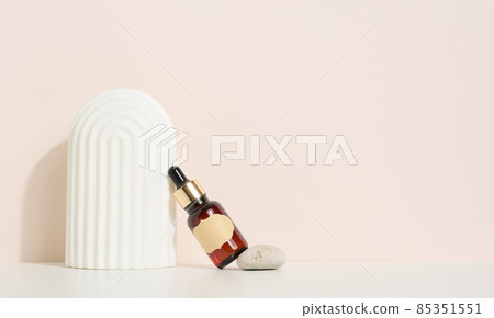 brown glass bottle with a pipette and a brown label stands on a stone. Container for cosmetics, serum and oil. Mockup skincare product 85351551