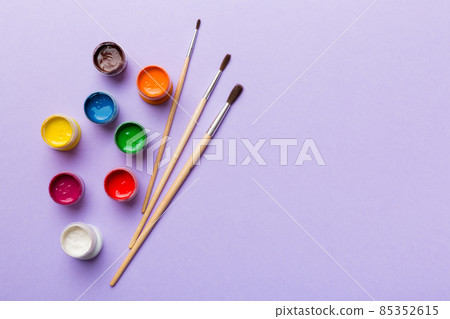 art palette with paint and brushes, close up. Top view with empty space. workplace for creativity. home teaching concept drawing 85352615