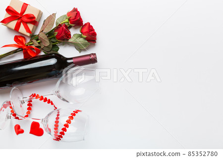 Valentine's day composition with red wine, rose flower and gift box on table. Top view, flat lay. Holiday concept Valentine's day composition with red wine, rose flower and gift box on table. Top view, flat lay. Holiday concept 85352780