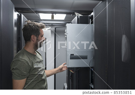IT engineer working In the server room or data center The technician puts in a rack a new server of corporate business mainframe supercomputer or cryptocurrency mining farm.  85353851