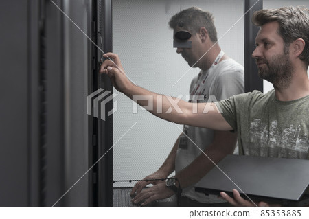 Technicians team updating hardware inspecting system performance in super computer server room or cryptocurrency mining farm. Technicians team updating hardware inspecting system performance in super computer server room or cryptocurrency mining farm. 85353885