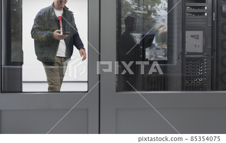 Technicians team updating hardware inspecting system performance in super computer server room or cryptocurrency mining farm. 85354075