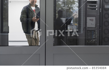 Technicians team updating hardware inspecting system performance in super computer server room or cryptocurrency mining farm. Technicians team updating hardware inspecting system performance in super computer server room or cryptocurrency mining farm. 85354084