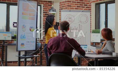 Diverse team of colleagues listening to business presentation 85354226