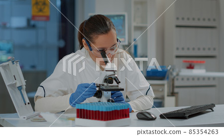 Microbiologist working with microscopic tool to research substance Microbiologist working with microscopic tool to research substance 85354263