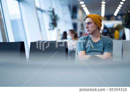 Man is sitting at the airport, waiting for flight. Man is sitting at the airport, waiting for flight. 85354310