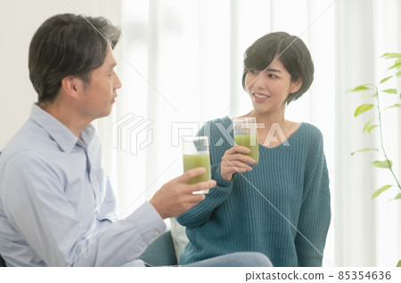 Father and daughter drinking vegetable juice 85354636