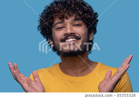 Man with palms up smiling at the camera 85355326