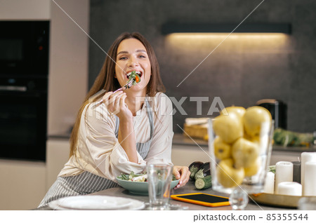 Cute positive woman in the kitchen Cute positive woman in the kitchen 85355544
