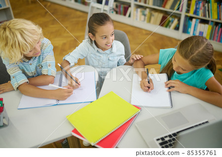 Top view of children writing at table in library Top view of children writing at table in library 85355761