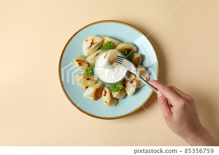 Concept of tasty eating with vareniki or pierogi on beige background Concept of tasty eating with vareniki or pierogi on beige background 85356759
