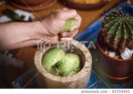 Process of cooking tacos with grilled flank beef steak with handmade guacamole. Squeezing lime Process of cooking tacos with grilled flank beef steak with handmade guacamole. Squeezing lime 85358405