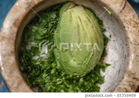 Process of preparing handmade guacamole. 85358409