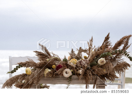 A table  designed for a boho style event with an eucalyptus, vintage plates and other rustic touches. On seaside in the sand 85359083