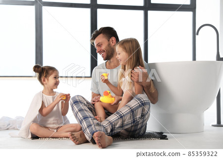 Father with little daughters near tub in bathroom Father with little daughters near tub in bathroom 85359322