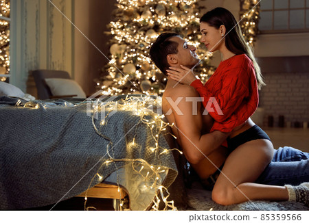 Passionate young couple enjoying each other in room decorated for Christmas 85359566